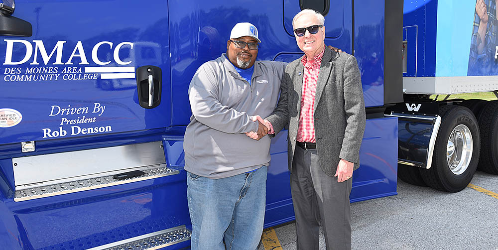 Travis Moore and DMACC's President Denson stand next to a DMACC truck