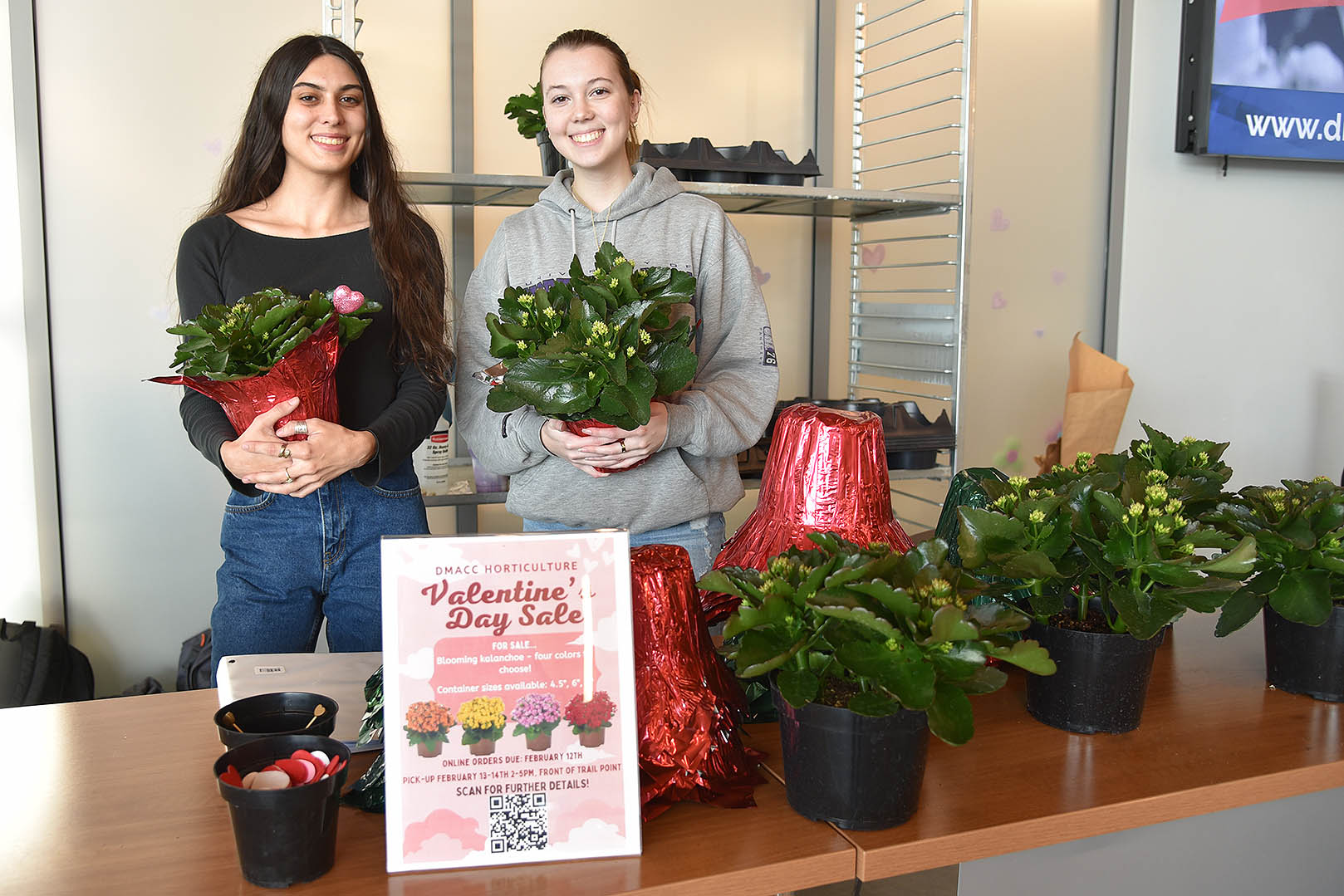 DMACC Horticulture students Danii​ Brady (left) of Indianola and Kaylee Stites (right) of Des Moines showcase two of the approximately 400 kalanchoe plants they helped raise for the DMACC Horticulture Club's Valentine's Day Sale this year. 